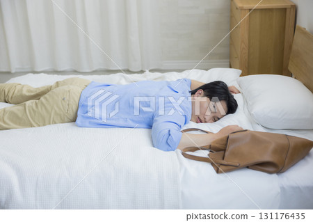 Man collapsing in bed Man collapsing in bed 131176435
