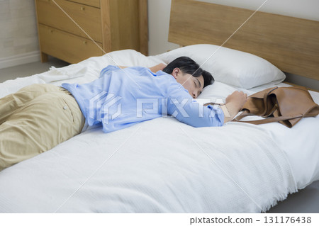 Man collapsing in bed Man collapsing in bed 131176438