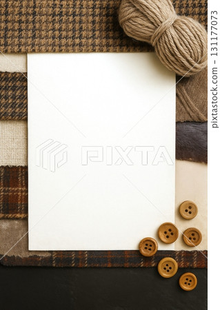 collage style of Blank white paper on fabric swatches with yarn and wooden buttons for crafting 131177073