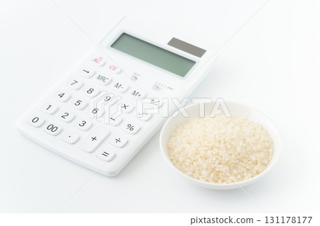 Calculator and white rice in a plate on a white background 131178177