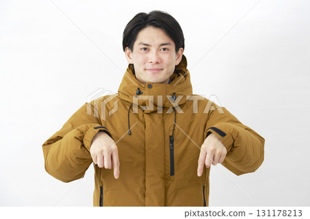 一名身穿羽絨外套的男子指著白色背景 131178213