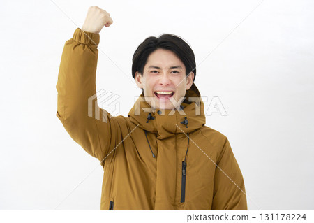 A man wearing a down jacket, fist pump, white background 131178224