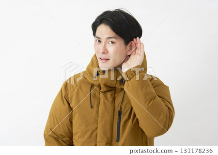 一位身穿羽絨外套的男子在白色背景上認真聆聽 131178236