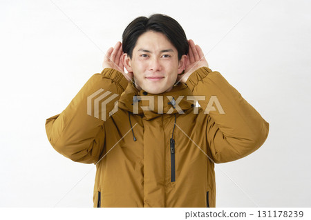 一位身穿羽絨外套的男子在白色背景上認真聆聽 131178239