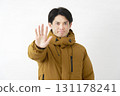 A man wearing a down jacket, posing in a restraining manner, white background 131178241