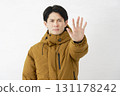 A man wearing a down jacket, posing in a restraining manner, white background 131178242