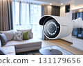 White security camera actively observing a modern home living room interior. Advanced digital surveillance system captures a wide view of the comfortable apartment space. 131179656