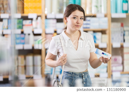 Girl in summer clothes buys medicinal ointment at pharmacy Girl in summer clothes buys medicinal ointment at pharmacy 131180900