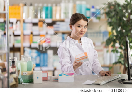 Female pharmacist looking for pills on computer Female pharmacist looking for pills on computer 131180901