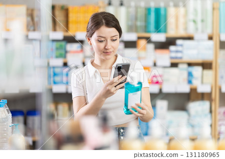 woman scans a mouthwash on her phone 131180965