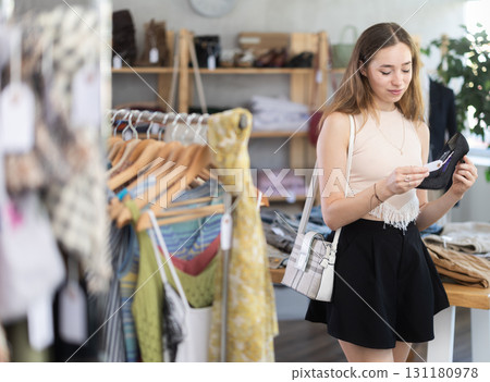 Young woman choosing heels in clothing store 131180978