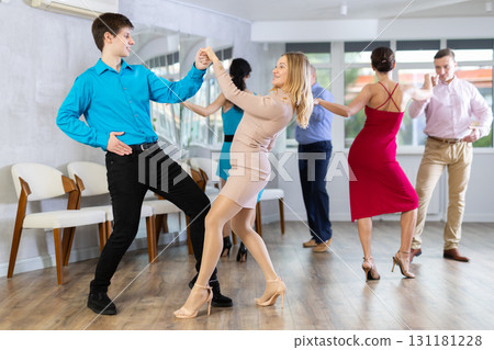 Cheerful woman practicing playful swing with guy during dance class Cheerful woman practicing playful swing with guy during dance class 131181228