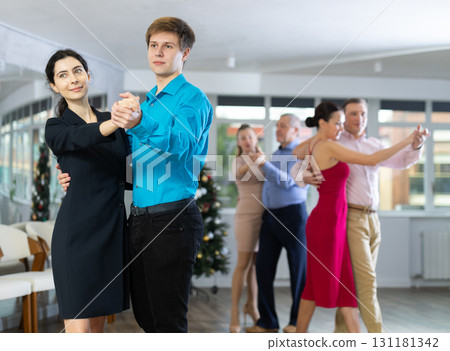 Elegant guy and stylish woman enjoying slow foxtrot at corporate New Year party 131181342