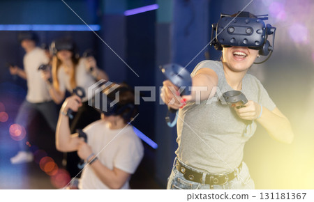 Emotional young woman in VR headset immersed in virtual game 131181367