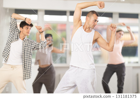 Group of energetic hip hop dancers focused on training while gathered together in spacious dance hall Group of energetic hip hop dancers focused on training while gathered together in spacious dance hall 131181375