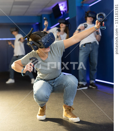 Girl is enjoying exciting movie with friends in VR glasses in room 131181381