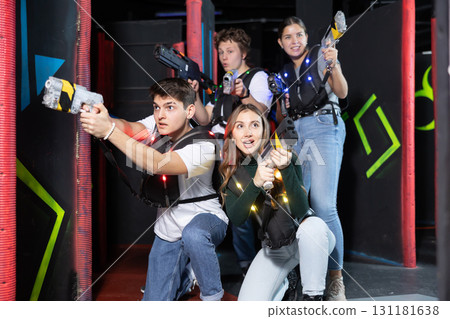 Laser tag players young mens and womens playing in teams in dark laser tag station 131181638