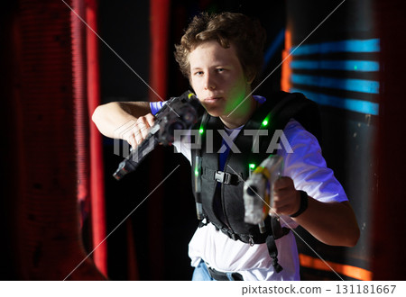 Excited teenager having fun playing lasertag in arena Excited teenager having fun playing lasertag in arena 131181667