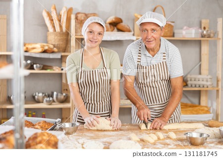 Male and female bakers kneading and cutting dough 131181745