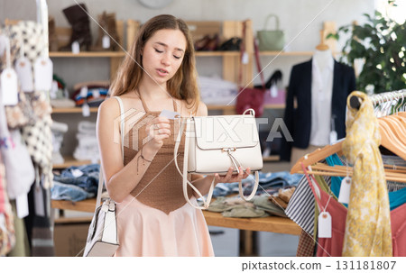 Selective young woman choosing handbag in clothing store Selective young woman choosing handbag in clothing store 131181807