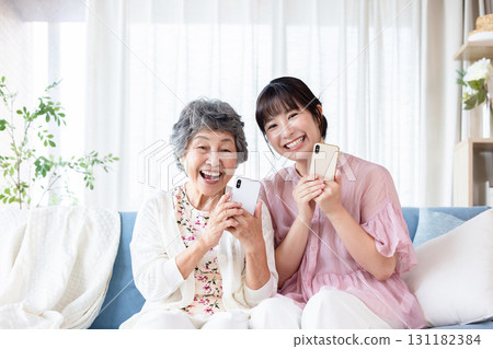 Senior woman and young woman with smartphones Senior woman and young woman with smartphones 131182384