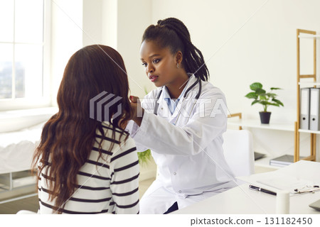 Black Female Doctor Examining Patient in Hospital Black Female Doctor Examining Patient in Hospital 131182450