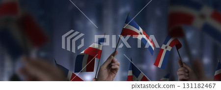 Dominicana flags in their hands on a blurred urban background 131182467
