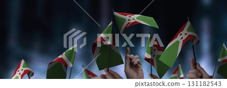 Burundi flags in their hands on a blurred urban background 131182543