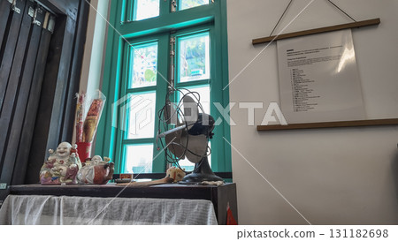Sept 14 2025 Cozy Indoor Desk Scene With Buddha Statues, Fan, Sept 14 2025 Cozy Indoor Desk Scene With Buddha Statues, Fan, 131182698