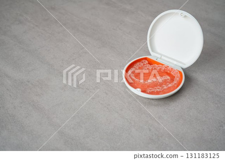 Orange and white case containing orthodontic aligners Orange and white case containing orthodontic aligners 131183125