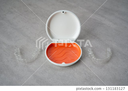Orange and white case containing orthodontic aligners 131183127