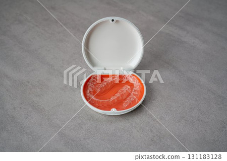 Orange and white case containing orthodontic aligners 131183128