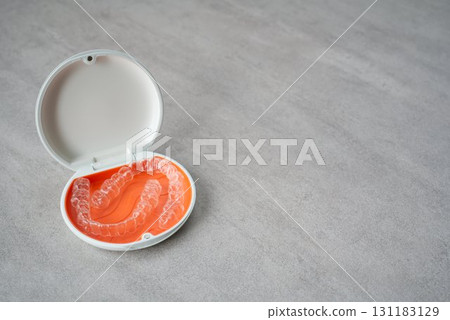 Orange and white case containing orthodontic aligners 131183129
