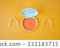 Orange and white case containing orthodontic aligners 131183715