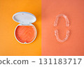 Orange and white case containing orthodontic aligners 131183717