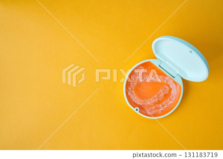 Orange and white case containing orthodontic aligners 131183719