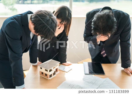 Depressed and disappointed businessmen and women at a conference table Depressed and disappointed businessmen and women at a conference table 131183899