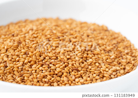 Close-up of golden sesame seeds (raw sesame seeds) in a plate 131183949