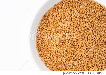 Close-up of golden sesame seeds (raw sesame seeds) in a plate 131184058