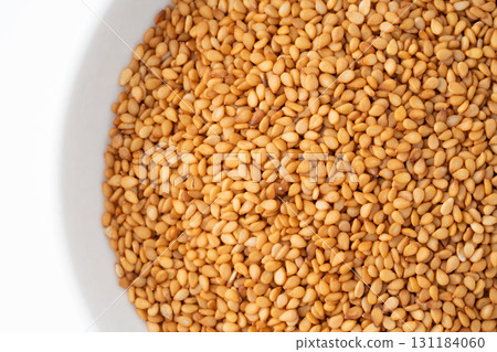 Close-up of golden sesame seeds (raw sesame seeds) in a plate 131184060
