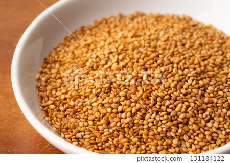 Close-up of golden sesame seeds (raw sesame seeds) in a plate Close-up of golden sesame seeds (raw sesame seeds) in a plate 131184122