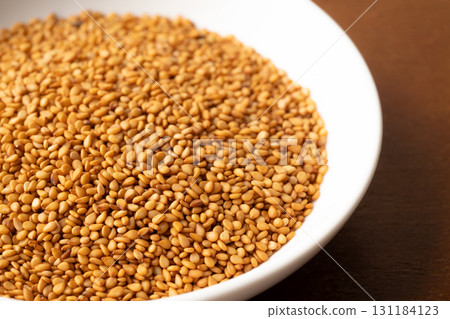 Close-up of golden sesame seeds (raw sesame seeds) in a plate Close-up of golden sesame seeds (raw sesame seeds) in a plate 131184123
