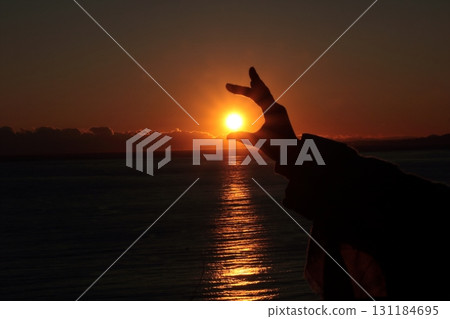 一個人用手托住夕陽的輪廓 一個人用手托住夕陽的輪廓 131184695