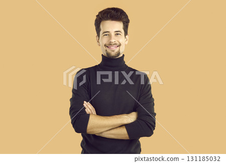Portrait of confident young man crossing hands smiling at camera 131185032