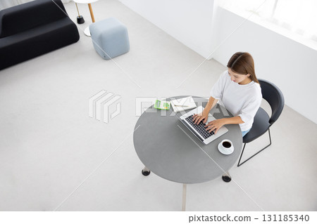 An overhead shot of a woman using a laptop at a table 131185340