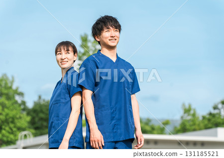 醫院或醫療機構前穿著工作服的男女醫護人員（職能治療師和護士） 131185521