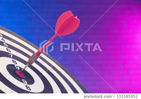 A dart successfully strikes the bullseye on the target board 131185852
