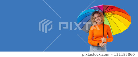 Brightly dressed individual joyfully holds a vibrant umbrella 131185860