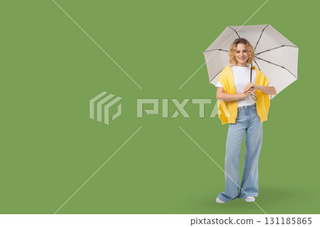 Woman stands confidently with her umbrella enjoying sunny weather 131185865