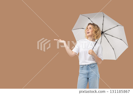 Woman stands cheerfully with umbrella enjoying the nice day 131185867